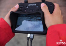 Un operador vuela el dron y sigue la imagen desde la pantalla en una competición de playa. Autor: Javier Sánchez-RFESS