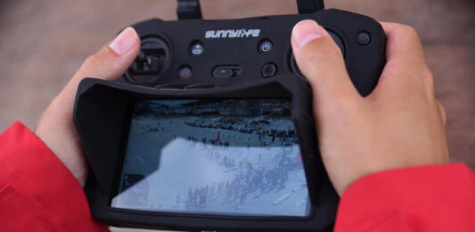 Un operador vuela el dron y sigue la imagen desde la pantalla en una competición de playa. Autor: Javier Sánchez-RFESS