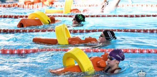 Socorristas femeninas clican el tubo de rescate alrededor del maniquí para iniciar el remolque en la prueba de 100 metros socorrista en el Pabellón Esperanza Lag de Elche (Alicante) durante la segunda edición de la Spanish Cup. Autor: Javier Sánchez/RFESS