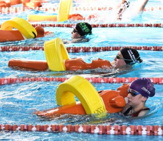 Socorristas femeninas clican el tubo de rescate alrededor del maniquí para iniciar el remolque en la prueba de 100 metros socorrista en el Pabellón Esperanza Lag de Elche (Alicante) durante la segunda edición de la Spanish Cup. Autor: Javier Sánchez/RFESS