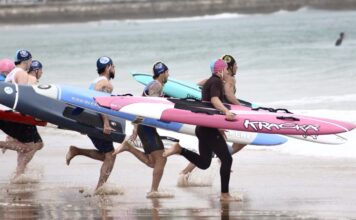Socorristas absolutos realizan la salida de la prueba de Carrera con tabla de salvamento para adentrarse en la Primera Playa del Sardinero, en Santander, durante la II Spanish Spring Beach Cup. Autora: Rosana Fuset-RFESS