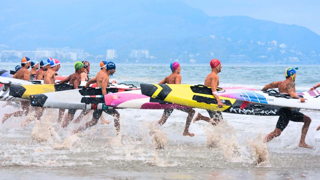 Socorristas absolutos realizan la salida de la prueba de carrera con tabla de salvamento durante el XXXVII Campeonato de España de Verano de Salvamento y Socorrismo en la Playa del Gurugú. Autora: Rosana Fuset -RFESS